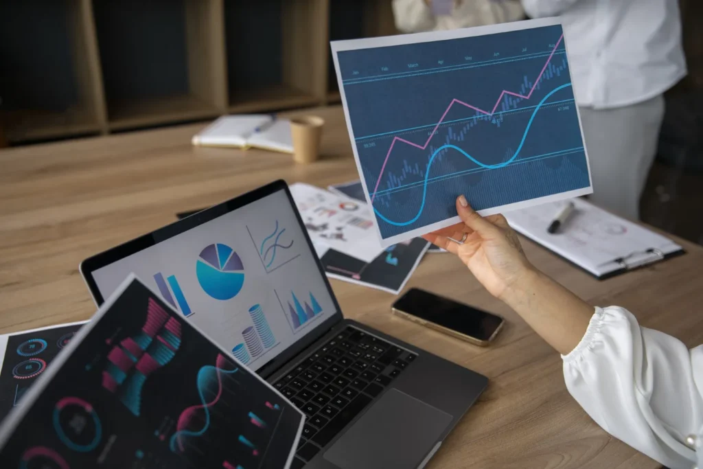 Specjalista SEO analizuje na laptopie wykresy wzrostu widoczności sklepu e-commerce.