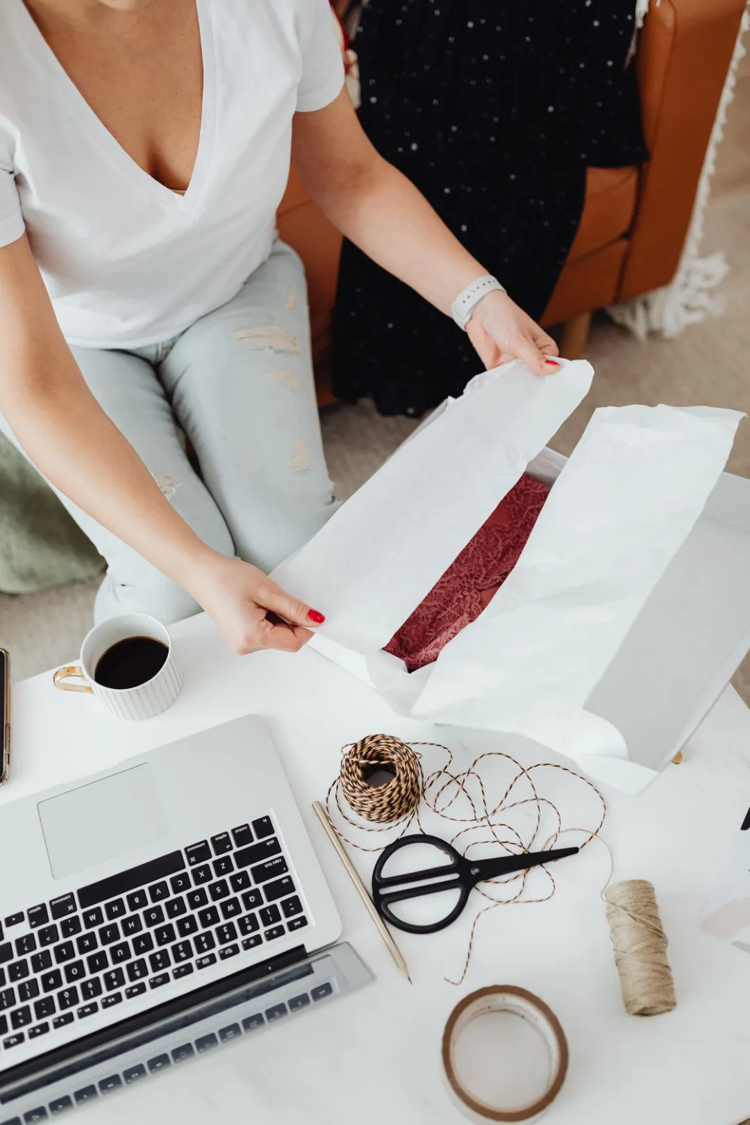 Kobieta pakuje paczkę z zamówienia Etsy przed wysyłką