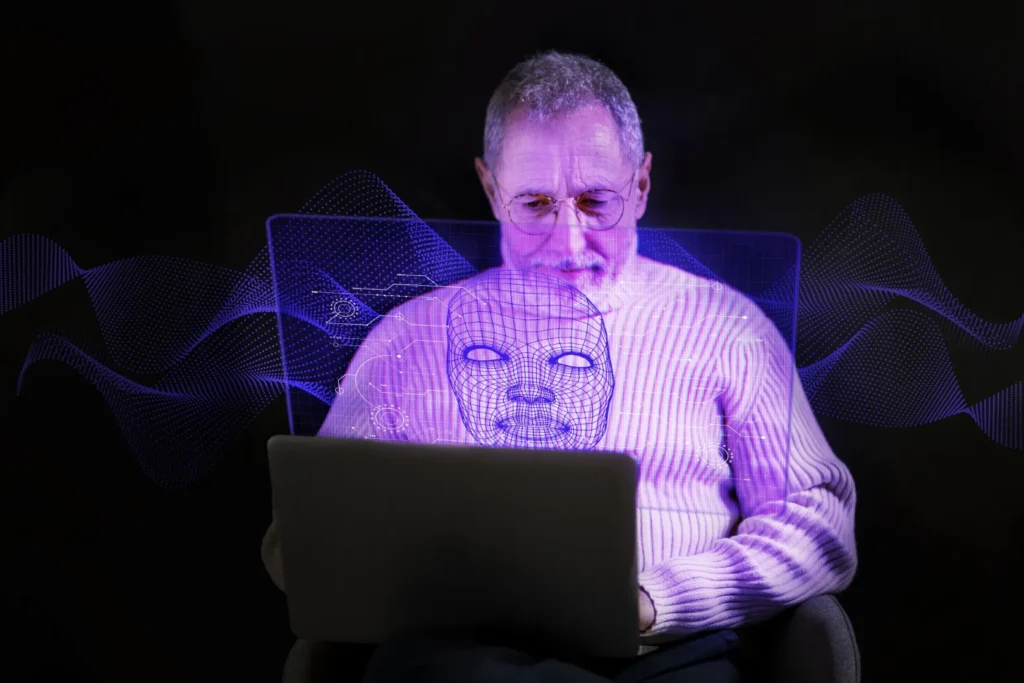 starszy mężczyzna siedzi przed laptopem