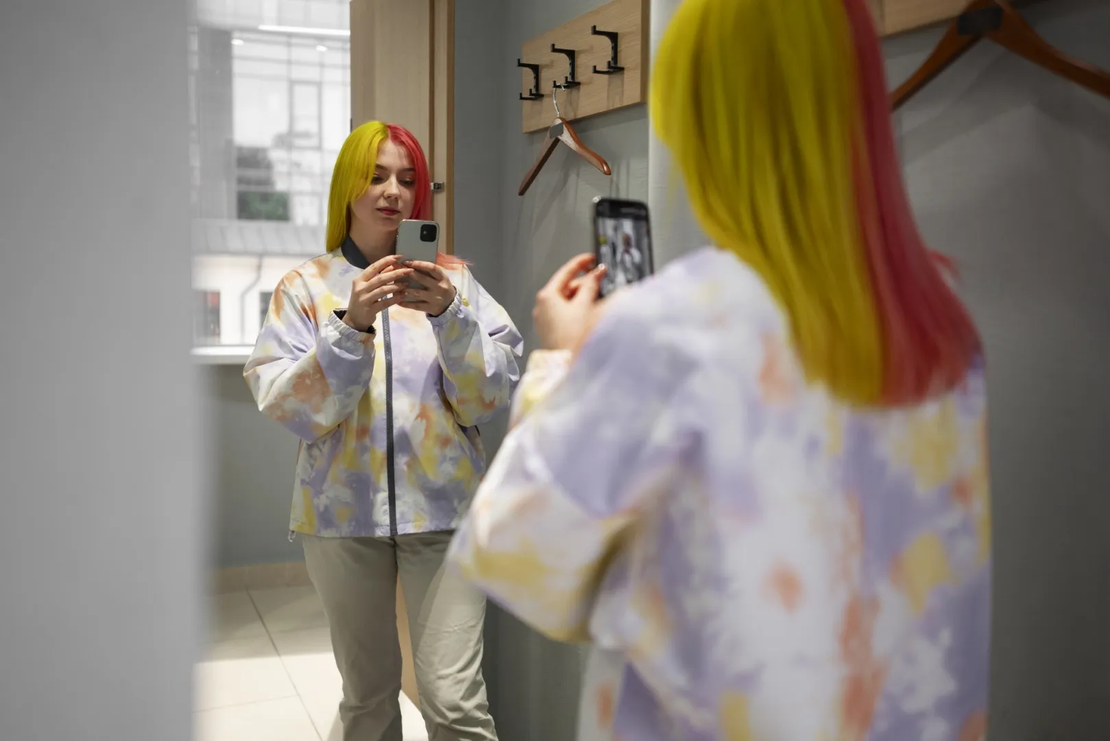 Twórczyni nagrywa wideo do TikTok Shop telefonem przed lustrem podczas transmisji Live